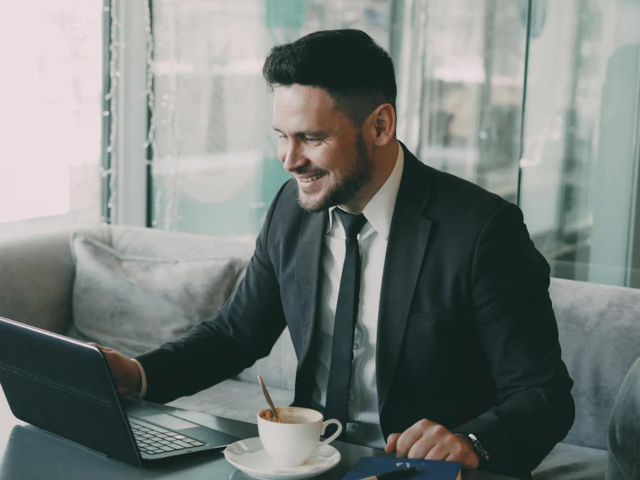 Hombre de negocios sonriendo mientras trabaja en su laptop